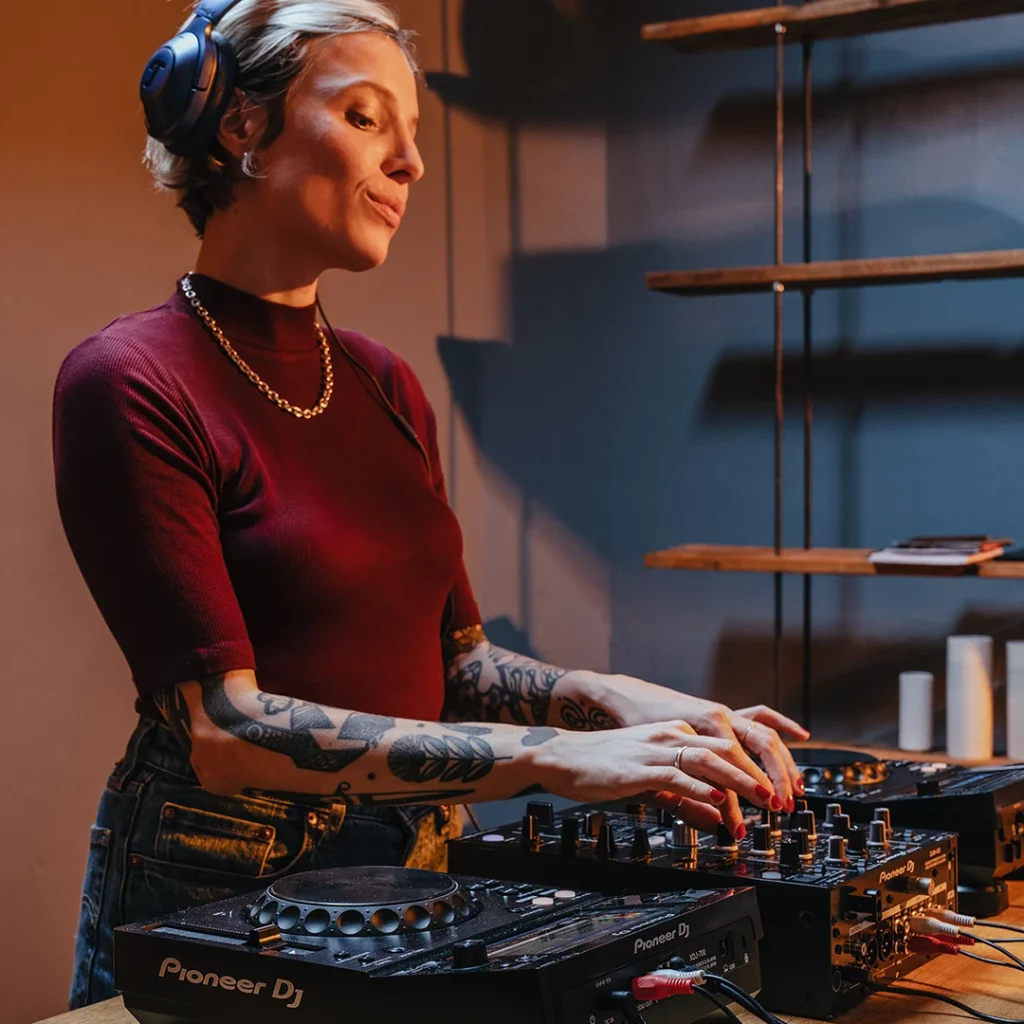 Vrouwlijke dj met een mengpaneel van Pioneer met twee mixers.